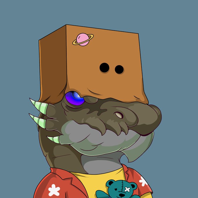 The image shows a cartoon dragon-like creature wearing a yellow shirt and red Hawaiian-style jacket with flower patterns, holding a teal teddy bear. On its head sits a brown cardboard box decorated with a pink Saturn decal and two black dots resembling eyes, reflecting the post's theme of a unique 1/1 NFT artwork where mythical dragon gods and handmade elements merge into a singular collectible piece.
