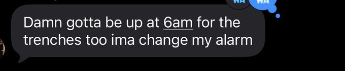 A dark-themed text message reads: "Damn gotta be up at 6am for the trenches too ima change my alarm." The image humorously reflects the "state of the trenches" by suggesting that someone has to wake up early specifically to engage with trading/market activity, treating it like a job.