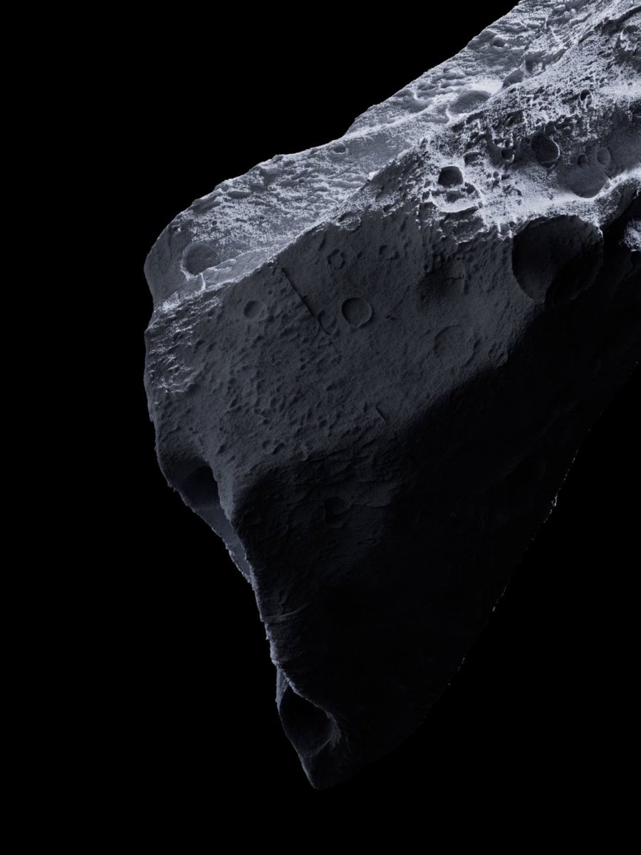 A detailed grayscale image of a heavily cratered asteroid or rocky celestial body floating against the black background of space.