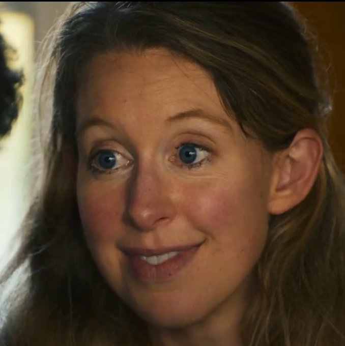 A close-up of a woman with striking blue eyes giving a skeptical, side-eye glance with a tight smile, perfectly capturing the doubtful expression one might make in response to overly optimistic advice about buying Ether during a downturn.