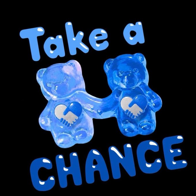 The image features two translucent blue gummy bear-shaped figures holding hands, each with a heart on their bellies containing a handshake symbol, accompanied by the text "Take a CHANCE" in blue bubble letters on a black background. The imagery reinforces the post's message about choosing love and optimism, with the handshake hearts symbolizing connection and partnership, while "CHANCE" cleverly doubles as both a play on the token ticker ($CHANCE) and a call to embrace opportunity with an open heart.