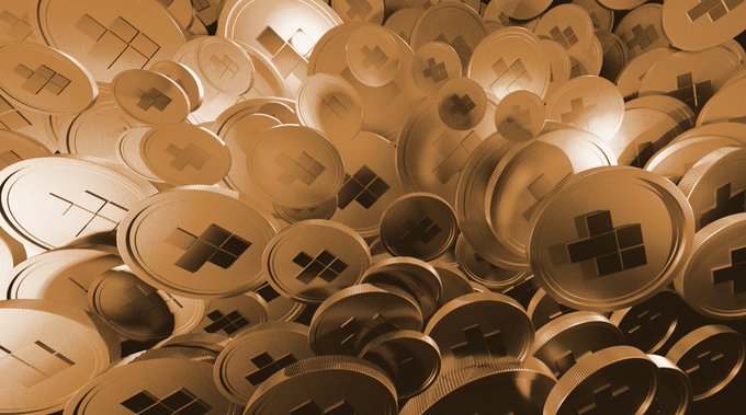 A pile of gold coins stamped with the GGBR logo representing the gold-backed token, visually reinforcing the post's message about Goldfish's $GGBR token, which is backed by 1/1000th of a troy ounce of physical gold per token.