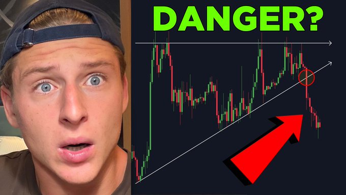 The image shows a shocked-looking man in a backwards cap alongside a candlestick chart labeled "DANGER?" in green, with a red circle and arrow highlighting a downward price trend below an upward trendline. This aligns with the post's warning about Bitcoin flashing a major warning signal, visually emphasizing the bearish breakout in the chart.