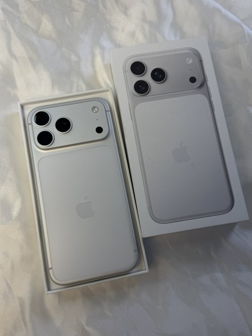 Two iPhones in their white packaging boxes sit on a wrinkled white sheet, suggesting a recent Apple product purchase or upgrade. The image humorously accompanies a post about taking profits in the 2026 bull market, with the phone upgrade serving as visual "proof" of financial success.
