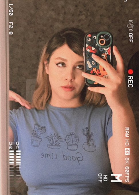 A woman takes a mirror selfie wearing a blue 'Good Times' t-shirt featuring cactus illustrations, with the image styled to look like a vintage camcorder recording showing 'CH2', 'REC', and '4K' overlays.