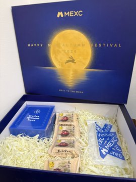An open MEXC gift box labeled 'Happy Mid-Autumn Festival 2023' with 'RISE TO THE MOON' text, containing various snacks, a Treasure Chest Power card, and branded items.