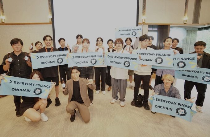 A group of attendees pose with "EVERYDAY FINANCE ONCHAIN" signs at a Bitget Wallet meetup, smiling and celebrating the gathering that highlighted the company as a pioneering force in mobile-based neobanking and onchain finance.