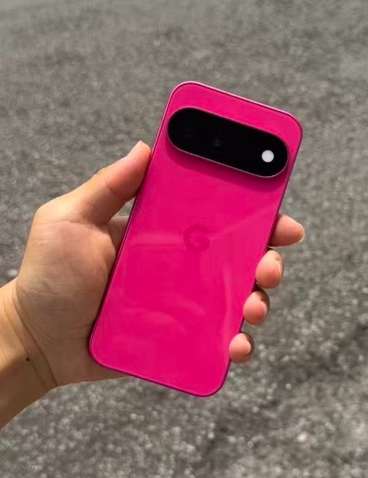 A hand holds a magenta/pink Google Pixel smartphone, displaying the Google logo and its distinctive camera bar against a gray asphalt background.