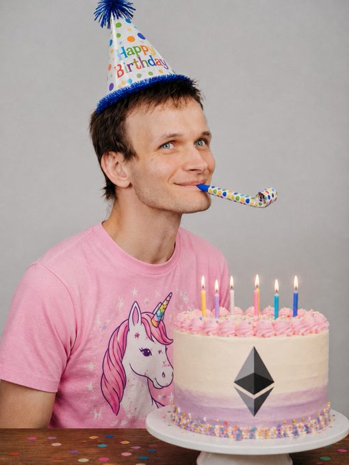 A man wearing a "Happy Birthday" party hat and a unicorn shirt blows a noisemaker next to a birthday cake decorated with an Ethereum logo and 11 lit candles, celebrating Ethereum's 11th anniversary on July 30, 2025, marking the network's evolution from its 2015 genesis block into a resilient "world computer."