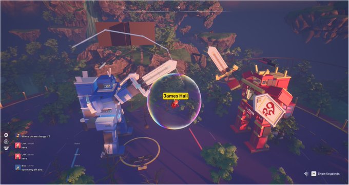 Video game scene featuring two large robots (one blue, one red) facing each other with a player named James Hall highlighted in a bubble.