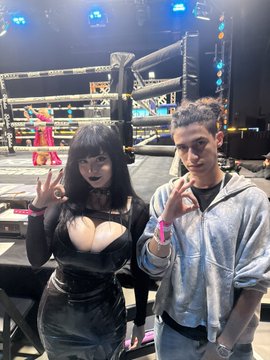 A man and woman pose together making peace signs in front of a boxing/MMA ring setup, with the woman wearing a black latex outfit and the man in a gray hoodie. The image appears to promote a giveaway offering $500 in $100 USDT (ETH) increments, using the event attendance as social proof to encourage engagement, likes, and retweets.