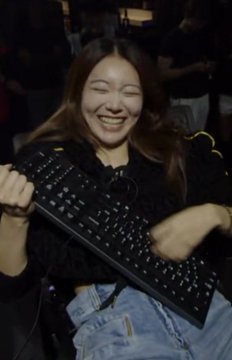 A young woman laughs joyfully while holding up a black keyboard, surrounded by falling casino chips, capturing the thrill of online gambling. Her exuberant expression aligns perfectly with the post about taking a gamble on Surge versus other betting sites for Solana and crypto deposits.