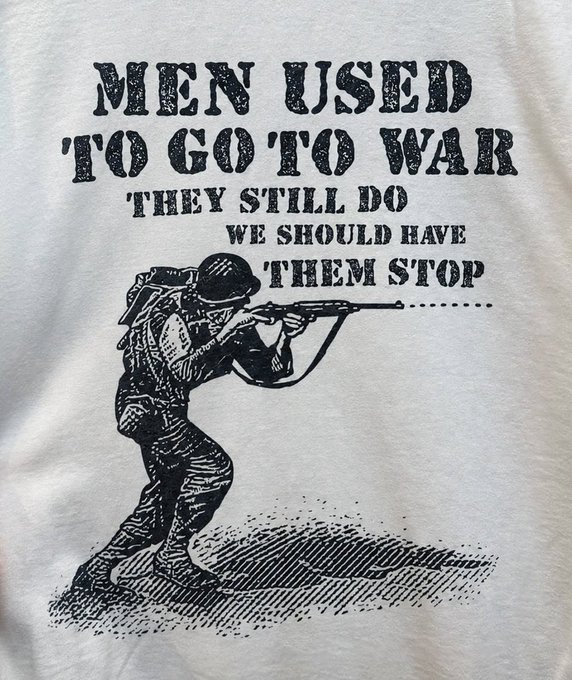 A vintage-style t-shirt featuring a black illustration of a soldier firing a rifle, accompanied by the text "MEN USED TO GO TO WAR THEY STILL DO WE SHOULD HAVE THEM STOP."