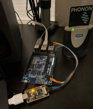 An electronics development setup featuring a blue development board connected via USB to a smaller programmer module, with a Western Digital 'My Passport' external hard drive visible in the background.