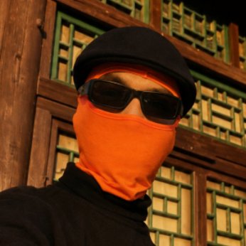 A person in a ski mask and sunglasses poses confidently in front of an ornate wooden architectural backdrop, projecting a hacker-like persona that aligns with the post's discussion of Bitcoin ecosystem vulnerabilities and the Bitcoiñ Red Team's audit revealing over 8,000 security flaws following the Coldcard hack.
