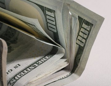 A close-up of a fanned stack of United States one hundred dollar bills.