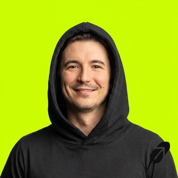 A smiling man wearing a black hoodie is pictured against a bright green background, with the Robinhood feather logo visible in the bottom right corner.
