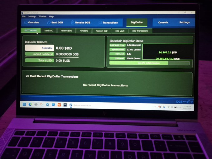 The image shows a laptop screen displaying the DigiDollar wallet interface, which highlights a "Blockchain DigiDollar Status" with a balance of 26,358,587.52 DGB and 24,265.21 $DD, visually supporting the "true freedom" claim associated with the $DGB token.