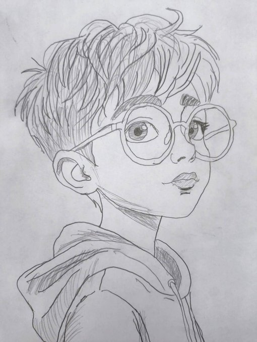 A pencil sketch on white paper portrays a young person with messy, textured hair and large round glasses, wearing a hoodie and looking slightly upward.