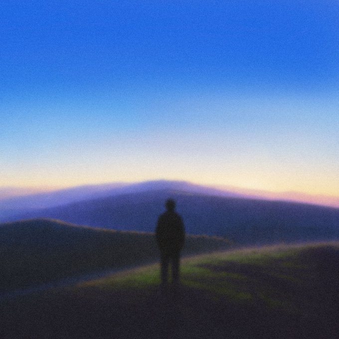 A silhouetted figure stands on a grassy hilltop at dusk, gazing out over a mountain range beneath a gradient sky of deep blue fading to soft orange.