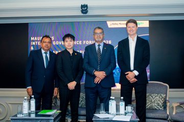 Four men in business attire pose together at the Mauritius Internet Governance Forum, as indicated by the visible "Mauritius Internet Governance Forum" backdrop text, with water bottles and conference materials arranged on a table in front of them. The image visually supports the post's discussion of responsible digital governance and inclusion at this forum, alongside the social media tag @ChainforGood and references to #Bybit and a #NewFinancialPlatform.