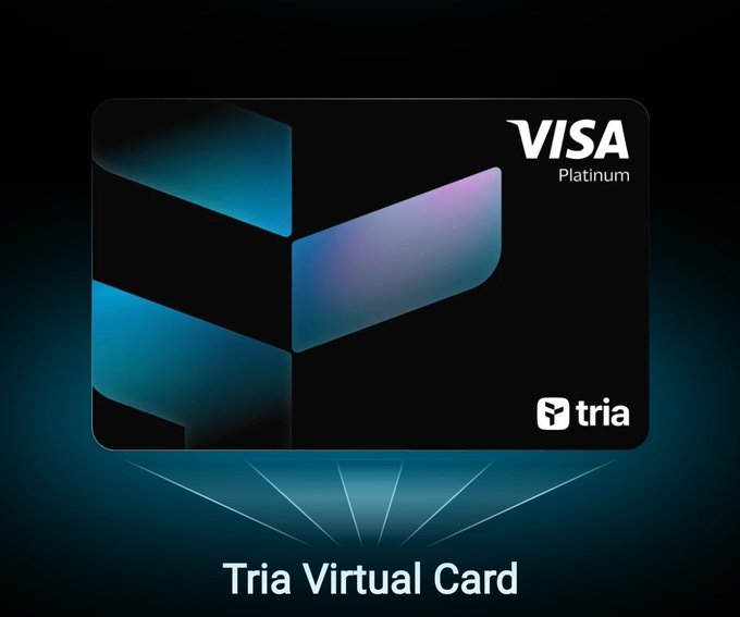 The image features a black Visa Platinum virtual credit card displayed against a dark background. The card has a unique design featuring a blue and purple triangle, which stands out prominently. Below the card, there's text that reads "Tria Virtual Card" in white letters. This suggests that the card is specifically designed for use on the Tria virtual currency platform.
