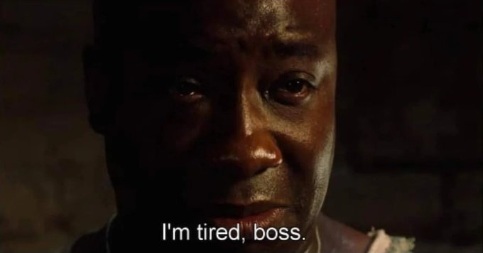 A close-up of a tearful, exhausted Black man with the subtitle "I'm tired, boss." connects to the post by visually capturing the weary, drained expression of a general counsel forced to deal with legal matters outside of normal hours.