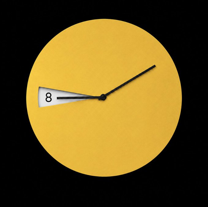 A minimalist clock design by Junghans features a yellow circular face displaying "8" on the hour hand, visually representing August (八月) on a timepiece. The image pairs with the greeting "GM八月，你好" to mark the arrival of the month.