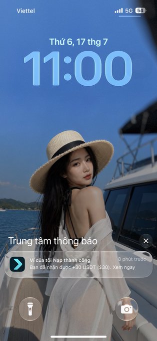 A Viettel phone lock screen showing 11:00 on Thursday, July 17, featuring a young woman in a straw hat on a boat, with a notification about a successful deposit of over 30 million VND.