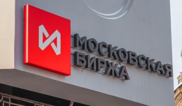 A sign for 'МОСКОВСКАЯ БИРЖА' (Moscow Exchange) featuring its red square logo with a white 'M'.