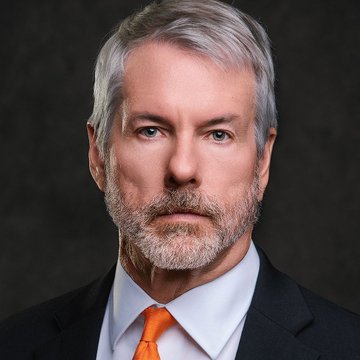 The image shows a man wearing a black suit jacket with an orange tie standing against a dark background. He has a serious expression on his face. The text at the bottom of the image reads "@saylor'S Bitcoin empire is facing its biggest stress test yet. $MSTR fell more than 5% in a single session and is now trading around $116, far below its 52-week highs near $457. The bigger concern is STRC, Strategy's preferred stock financing vehicle, which recently". The man appears to be concerned about the current market situation involving Bitcoin.