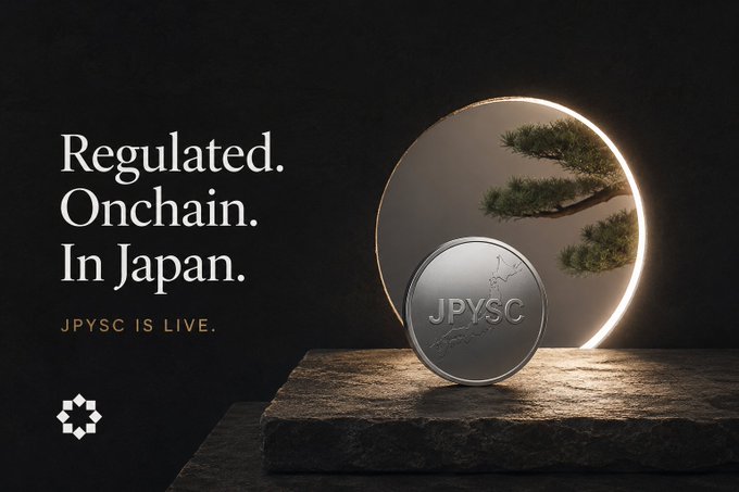 A sleek promotional graphic announcing "JPYSC IS LIVE" with the headline "Regulated. Onchain. In Japan." features a silver coin embossed with "JPYSC" and a map of Japan, displayed against a dark backdrop with a glowing circular frame and bonsai tree, visually reinforcing the stablecoin's official launch as Japan's regulated, trust bank-backed yen stablecoin.