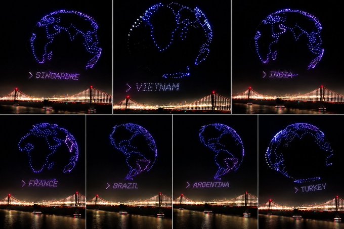 A collage of seven night images showing drone light formations creating globes over the Bay Bridge, each labeled with country names: Singapore, Vietnam, India, France, Brazil, Argentina, and Turkey.