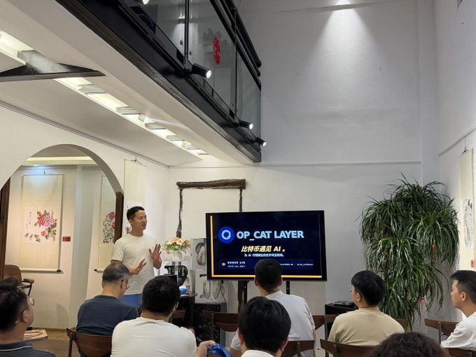 The image shows a group of people gathered around a television screen, watching a presentation or lecture about Bitcoin and AI agents. The room appears to be a conference room with a large TV mounted on the wall, which serves as the focal point for the audience. There are several chairs placed in front of the TV, indicating that this is an event where attendees can sit and listen to the speaker.

The people present seem engaged and interested in what is being discussed, suggesting that they might be learning about new developments or advancements related to Bitcoin and AI agents. The image captures a moment of shared knowledge and understanding among the audience members as they collectively explore these topics.