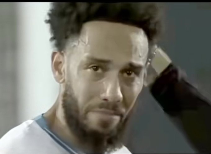 A close-up screenshot of NBA player Neymar Jr. with facial tattoos, appearing emotional while touching his head, likely from a documentary or interview.