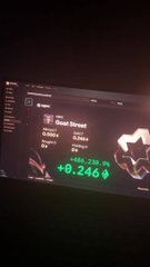 A blurry, low-quality photograph of a computer screen displaying a stock trading interface with green and red numbers, including '+0.246', with a white cartoon dog sticker overlaid on the right side.