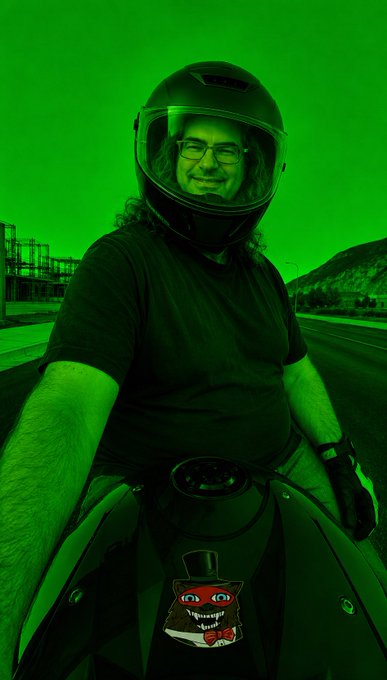 A man wearing a motorcycle helmet sits on his bike, smiling beneath his glasses while a green tint floods the entire scene, matching the post's playful jab at "going green" after a critic called $0.60 XRP—a visual punchline to the bullish sentiment, amplified by the grinning red goblin sticker on his fuel tank.