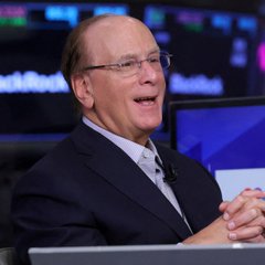 Larry Fink, CEO of BlackRock, is shown speaking at what appears to be a financial conference or interview setting, smiling with his hands clasped. The image connects to the post about BlackRock clients purchasing $134 million worth of Bitcoin, illustrating the firm's deepening involvement in cryptocurrency despite Fink's historically skeptical stance on digital assets.