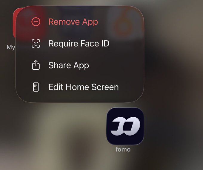 A long-press app menu shows options to Remove App, Require Face ID, Share App, and Edit Home Screen for the "fomo" app, humorously suggesting it's being removed because the stock is back to $0.