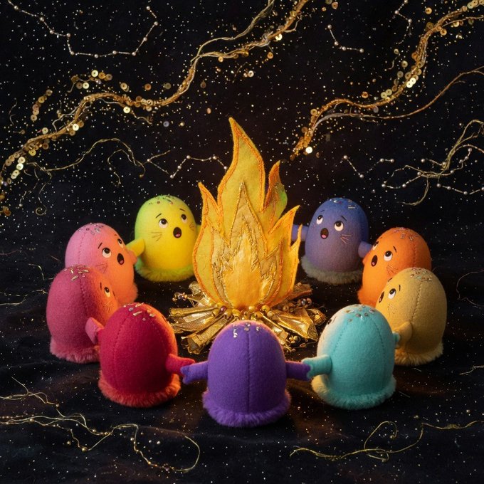 A circle of colorful, round plush figures gather around a glowing golden flame beneath a constellation-strewn sky, evoking the muses of creativity. The image visually echoes the post's theme of "999 muses" — each whimsical character appearing as a unique, named soul summoned by inspiration.
