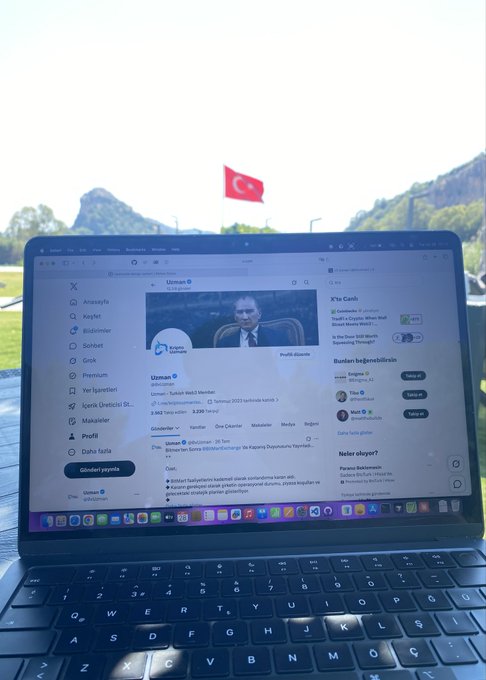 A laptop screen displaying the Turkish X (Twitter) feed outdoors, with a Turkish flag visible in the background.