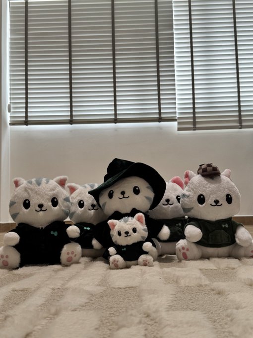 A collection of six "Hypurr" plush toys are arranged together on a blanket in front of window blinds, showcasing themed varieties including a Wizard Hypurr, Suited Hypurr, Detective Hypurr, OG Hypurr, Weighted Hypurr, and a mini keychain Hypurr.