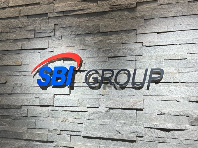 The logo for 'SBI GROUP' in blue and black letters with a red swoosh is mounted on a textured grey stone wall.
