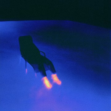 The image features a chair with its legs spread out, positioned against a dark blue background. The chair appears to be empty, creating an atmosphere of solitude or loneliness. The photo has been edited to enhance the contrast between the chair's legs and the surrounding darkness, making them stand out prominently in the frame. The image also contains text that reads "Just minted two pieces that mean a great deal to me. Though distinct in their own right, they feel deeply connected. Almost like two sides of the same conversation." This text seems to be related to the chair and its position within the scene.