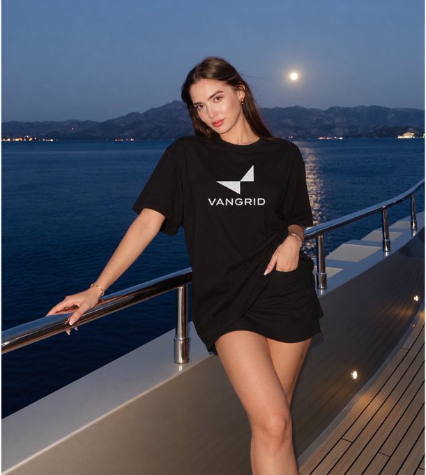 A woman poses at twilight on a yacht deck, wearing a black T-shirt featuring the "VANGRID" logo, tying into the post promoting the @vangrid_io campaign on Nucleus for Physical AI contributors with a $100K token airdrop.