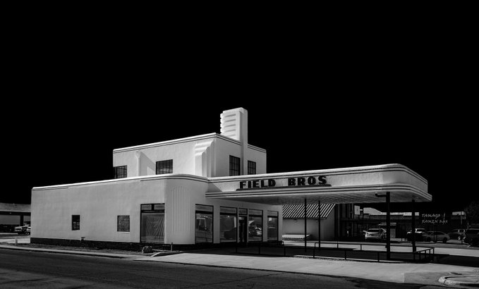 A black-and-white vintage photograph of an Art Deco-style commercial building featuring a prominent corner tower and a sign reading 'FIELD BROS.' above the entrance.
