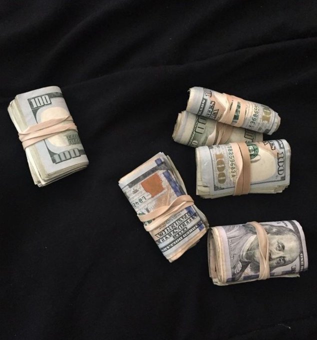 Multiple bundles of US currency, including $100 bills with serial numbers like KB59968226F, rest on a black surface, visually answering the question about making money with a literal display of cash.