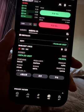 The image shows a person holding up their cell phone displaying a screen with various information related to stock trading. The phone's display features both green and red indicators, suggesting that there are positive and negative changes happening in the stock market at the moment. The person is also shown typing on the phone, possibly taking notes or making decisions based on the displayed data.