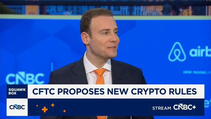 CNBC Squawk Box segment featuring a man in a suit with an orange tie, with a chyron reading 'CFTC PROPOSES NEW CRYPTO RULES' and an Airbnb logo in the background.
