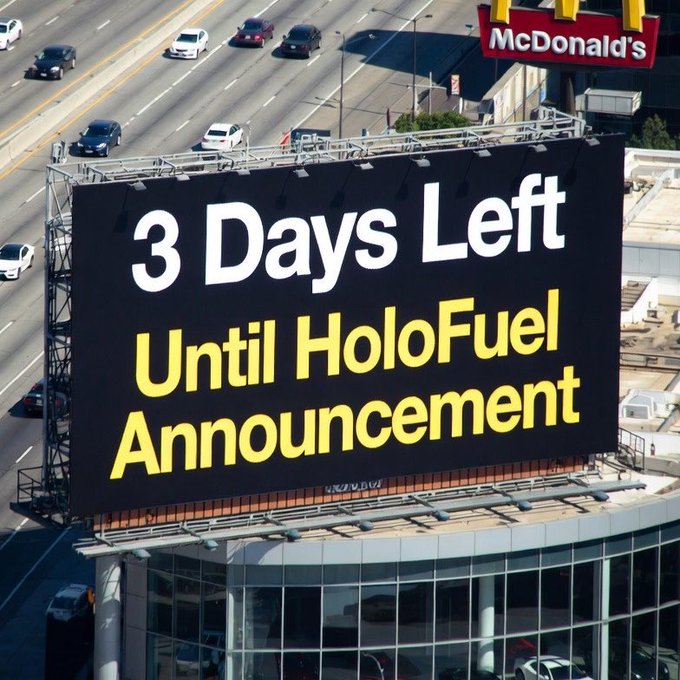 A large billboard near a McDonald's displays "3 Days Left Until HoloFuel Announcement" in white and yellow text, building anticipation for the Holochain-related HoloFuel ($HOT) launch referenced in the post.